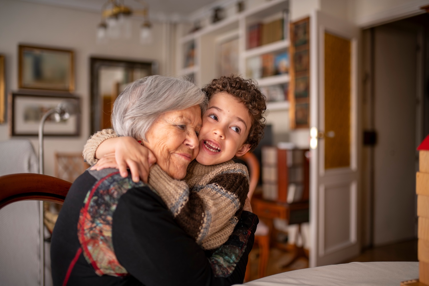 Grandson embracing his grandmother, expressing love and affection in a heartwarming moment at home